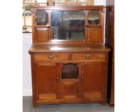 An Arts & Crafts oak sideboard fitted mirrored and panelled canopy back, base fitted two drawers, three lower cupboards and c
