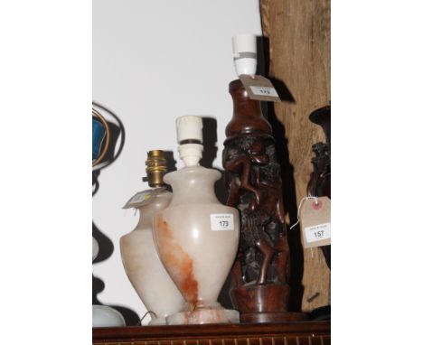 An African carved wood table lamp, stem carved and pierced figures, 16" high, and a pair of alabaster table lamps