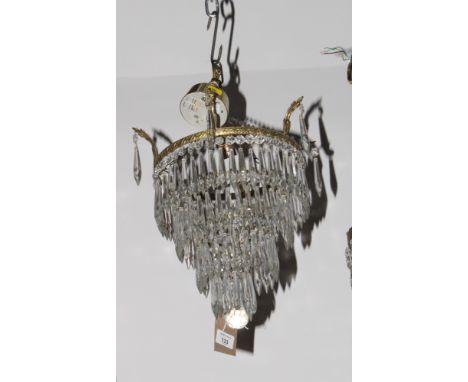 A gilt metal framed centre light hung four tiers of concentric elongated glass drops