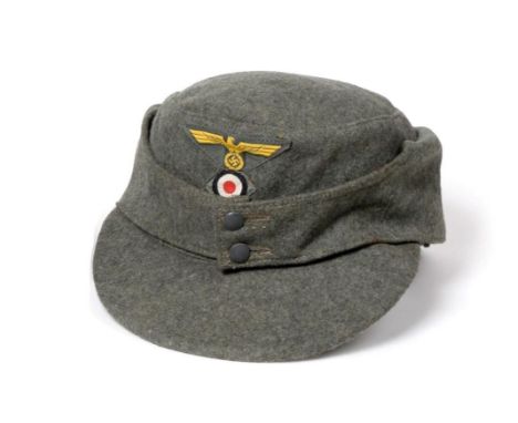 A German Third Reich M43 Army EM's/NCO's Field Cap, in field grey wool, with machine embroidered eagle and swastika over a ma