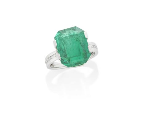 EMERALD SINGLE-STONE RINGThe octagonal step-cut emerald, between shoulders tension-set with brilliant-cut diamonds, emerald s