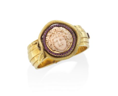 GOLD, CORAL AND GEM-SET BANGLE, MID 19TH CENTURYThe circular corallium rubrum cameo, depicting the head of Bacchus, on a gold