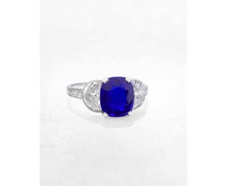 SAPPHIRE AND DIAMOND RING, CIRCA 1920The cushion-shaped sapphire, weighing 3.52 carats, between old demi-lune-shaped diamonds