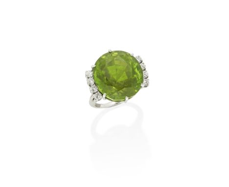 PERIDOT AND DIAMOND RINGThe circular-cut peridot between brilliant-cut diamonds, peridot very approximately 35.40 carats, rin