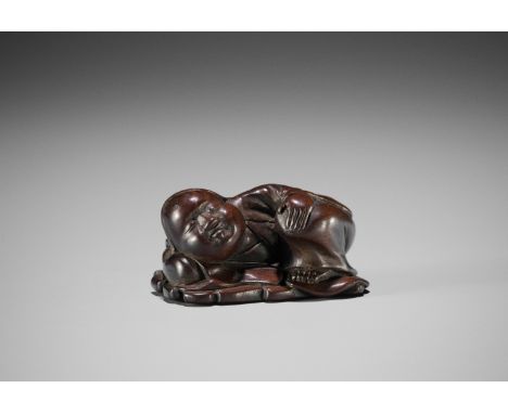 A FINE WOOD NETSUKE OF OKAME SLEEPINGJapan, mid-19th century, Edo period (1615-1868)Finely carved to depict Okame sleeping on