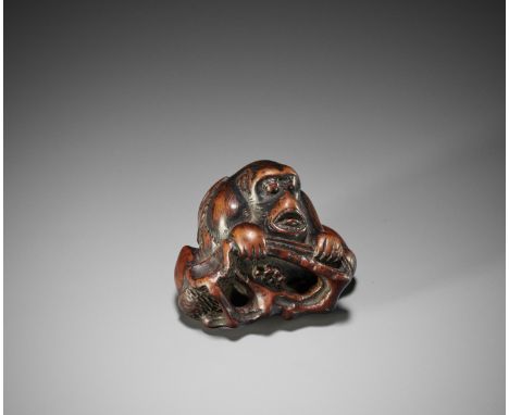AN UNUSUAL KYOTO SCHOOL NETSUKE OF A MONKEY WITH ACORNSJapan, Kyoto, early 19th century, Edo period (1615-1868)Boldly carved 