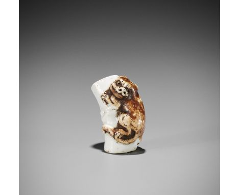 A HIRADO PORCELAIN NETSUKE OF A TIGER ON BAMBOOJapan, 19th century, Edo period (1615-1868)A Hirado-yaki netsuke of a tiger cl