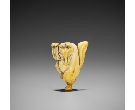 AN IVORY NETSUKE OF A DANCING KITSUNEJapan, 18th century, Edo period (1615-1868)Carved as a kitsune (fox), standing on one fo