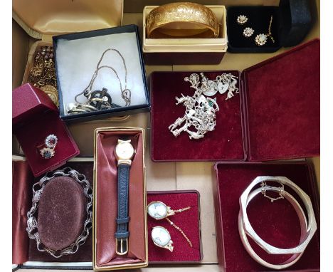 A collection of jewellery to include a silver charm bracelet, two silver bangles, a silver circular link bracelet, an engrave