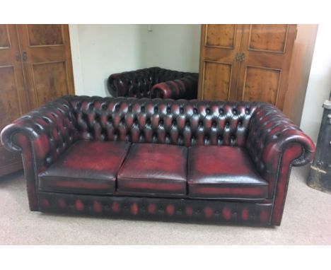 An Oxblood button back three seater chesterfield with matching chair.