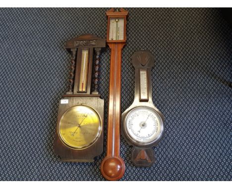 A reproduction mahogany stick barometer and two oak cased wall barometers.