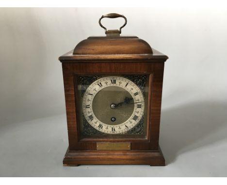 A brass faced mahogany mantel clock.