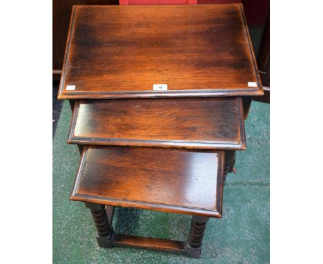 An oak nest of three tables, each with a moulded rectangular top, bobbin and ring turned supports, the largest 57cm wide