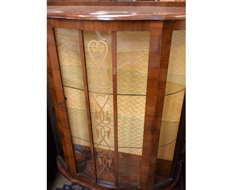 A 1920's single door bow front display cabinet, Art Nouveau central panel, two shelves 