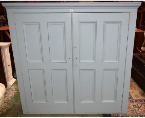 A Country house painted pine housekeeper's cupboard, outswept cornice above a pair of 'raised and fielded' panel doors enclos