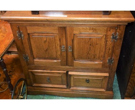 An oak side/media cabinet, rectangular top above a pair of panel doors and two short drawers, skirted base; a similar corner 