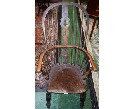 A Country House Windsor elbow chair, shaped pierced splat, turned arm supports, elm saddle seat, ring turned legs, H-stretche