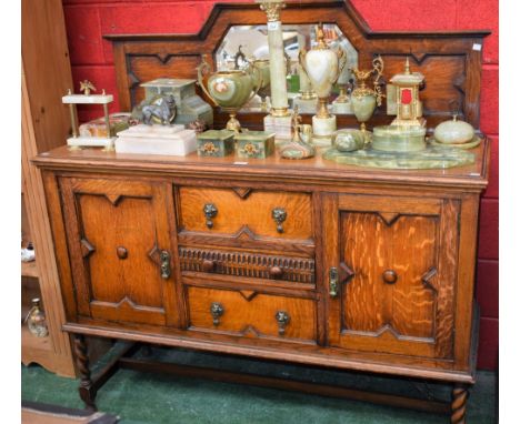 A Jacobean Revival oak sideboard, tall arched gallery centred by a mirror, moulded rectangular top above three drawers, the c