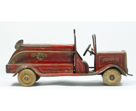 A vintage red painted metal fire engine, probably American, white rubber tyres, lacking ladder, 30cm.