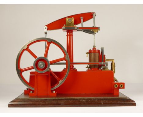 A Stuart Turner stationery beam engine comprising of red body with vertical single cylinder engine with steam and exhaust por