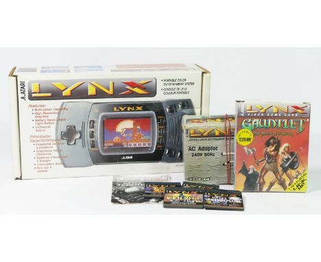 An Atari Lynx handheld console (PAG-0401), original box with manuals, AC adaptor, boxed, together with five Atari Lynx video 