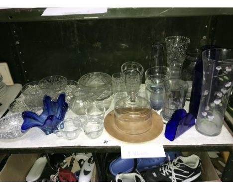 A shelf of glass ware including vases.