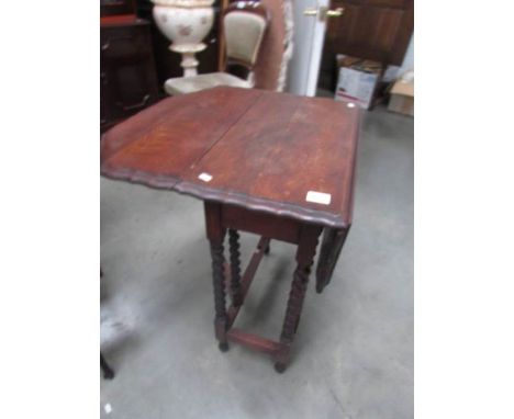 An oak gate leg table with pie crust edge.