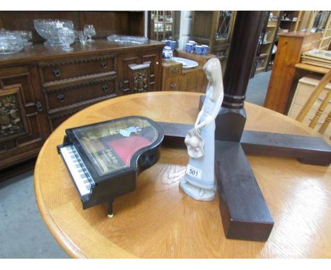 A Lladro style figure and a musical piano jewellery box.