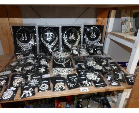 A shelf of bagged costume brooches and necklaces.