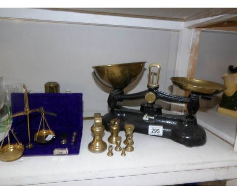 A set of kitchen scales with weights and a cased set of precious metal scales.