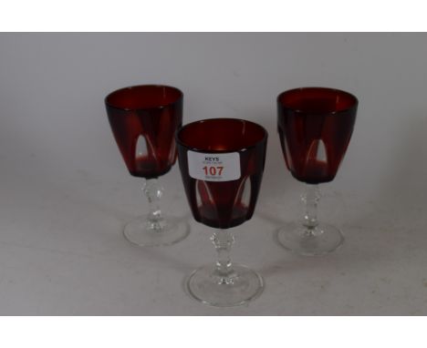 THREE RUBY COLOURED WINE GLASSES