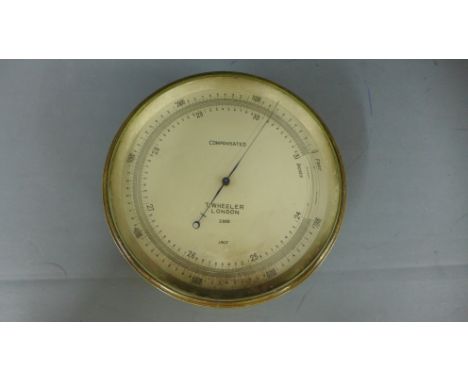 A brass compensated aneroid barometer by T Wheeler, London dated 1917 no 2888 - Diameter 12cm retailed by Gailey and Roberts 