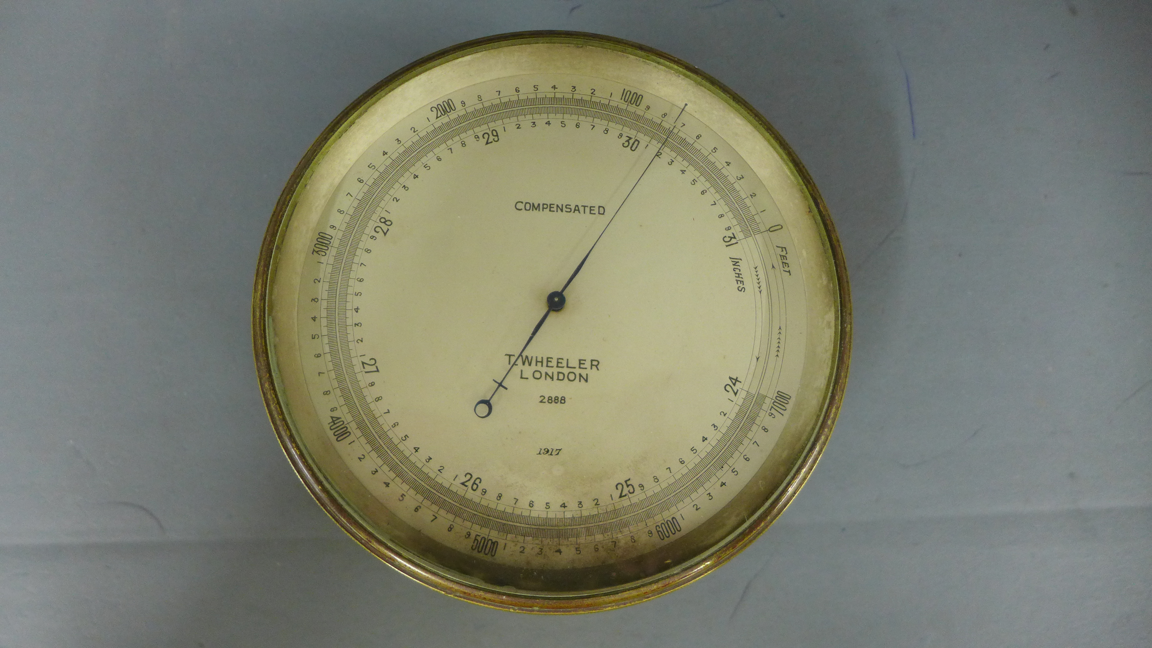 A brass compensated aneroid barometer by T Wheeler, London dated 1917 no 2888 Diameter 12cm ret