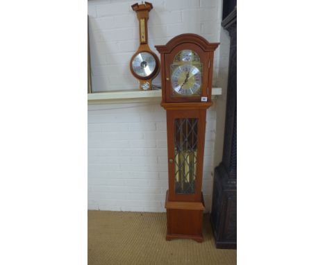 A modern three train granddaughter clock and a modern wall barometer 