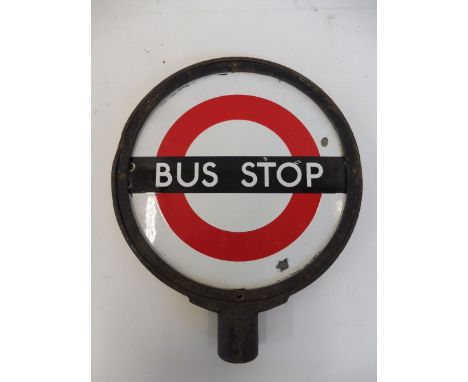 A pair of circular enamel Bus Stop signs, mounted back to back in a metal frame, 13 1/4" diameter. 