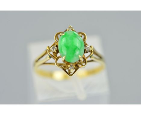 A JADE AND DIAMOND RING, the central oval jade cabochon within an open surround claw set with four single cut diamonds, stamp