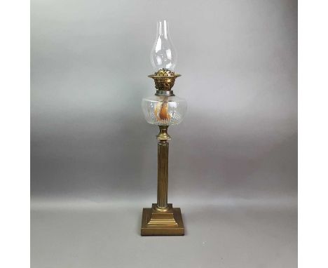 VICTORIAN OIL LAMP LATE 19TH CENTURY with clear glass chimney and fluted star cut reservoir, over a fluted brass column and s