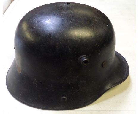 A German M16 steel helmet,  black finish with white Landwehr cross painted on the back, with original padded leather liner an