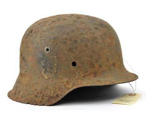 An excavated Third Reich M42 steel helmet,  with remains of SS and party decals, heavily corroded overall with several holes.