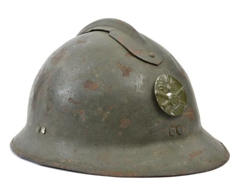 A French “Adrian” pattern steel helmet, stamped disc with “RF” grenade on crossed cannon, leather liner and chinstrap, stamps