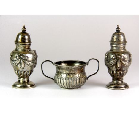 A pair of hallmarked silver pepperettes and a silver two handled cup.