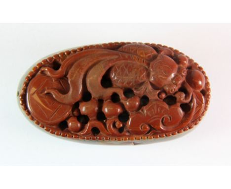 An intricately carved Chinese pebble hardstone scroll weight of a fan tail carp among lotus, L. 9cm.