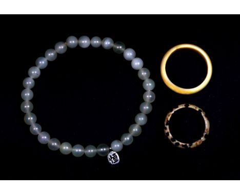 A jade bracelet, a speckled stone ring and an ivory ring.