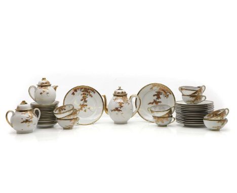 A Japanese tea service, 20th century, comprising a teapot, 20cm high, twin handled sugar pot and cover, 17cm wide, a cream ju