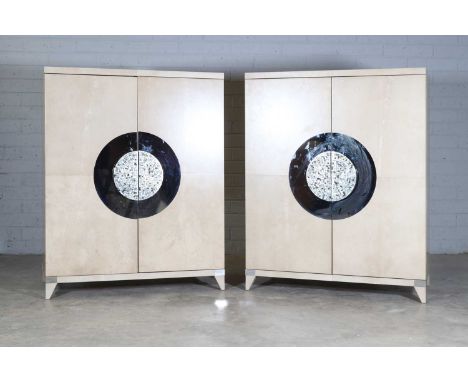 A pair of cream-coloured cabinets, of recent manufacture, each with two long doors supported on chamfered feet, with two glas