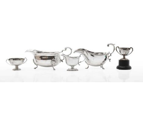 A collection of silver items comprising three sauceboats, including two examples with acanthus leaf handles, the largest 22cm