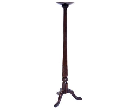 A mahogany plant stand, with a circular dish top on a leaf carved fluted column and tripod base, 59cm high, the top 29cm diam