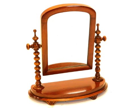 A Victorian mahogany bow fronted dressing table mirror, with arch plate on bobbin turned supports, 44cm wide.