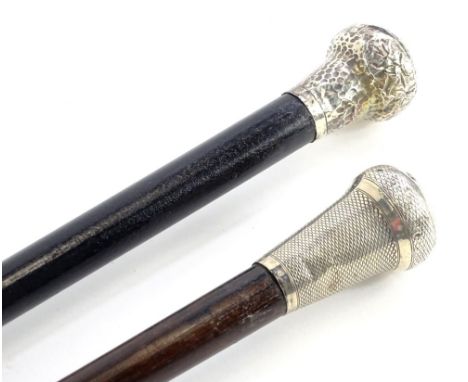 An ebonised walking stick, with silver collar with overall engraved decoration, and another similar with hammered decoration,