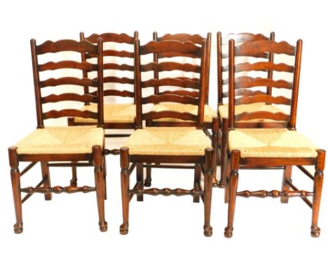 A set of six oak ladder back chairs, each with a rush seat on turned tapering legs.